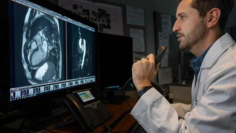 A radiologist reviewing MRI images and dictating a report